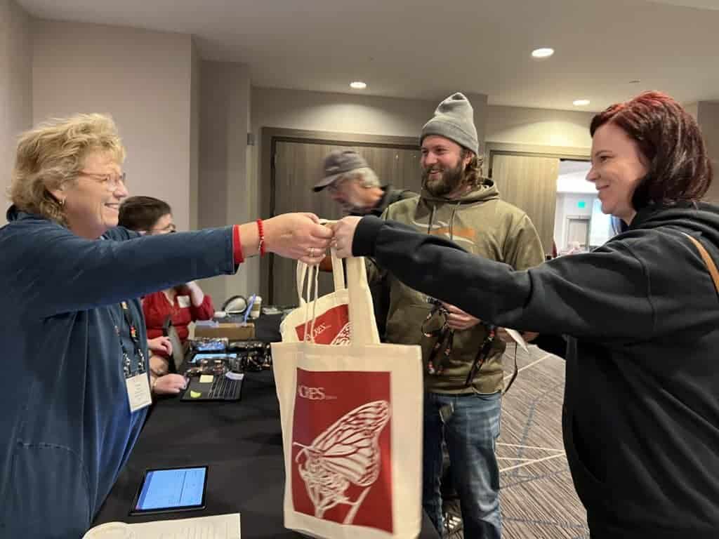 volunteer handing out a bag at Eco-Ag Conference registration