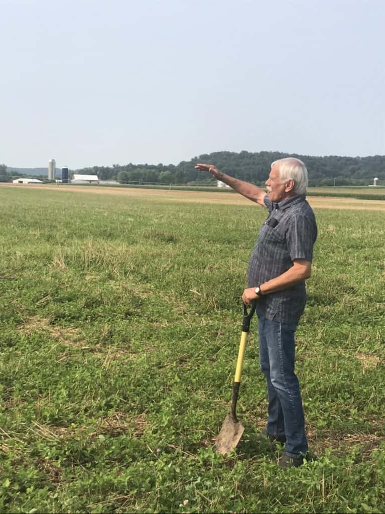 Gary Zimmer holding a shovel in his field
