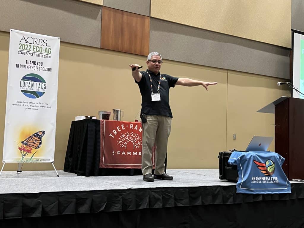 Reginaldo Haslett-Marroquin gestures on the 2022 Eco-Ag Conference stage