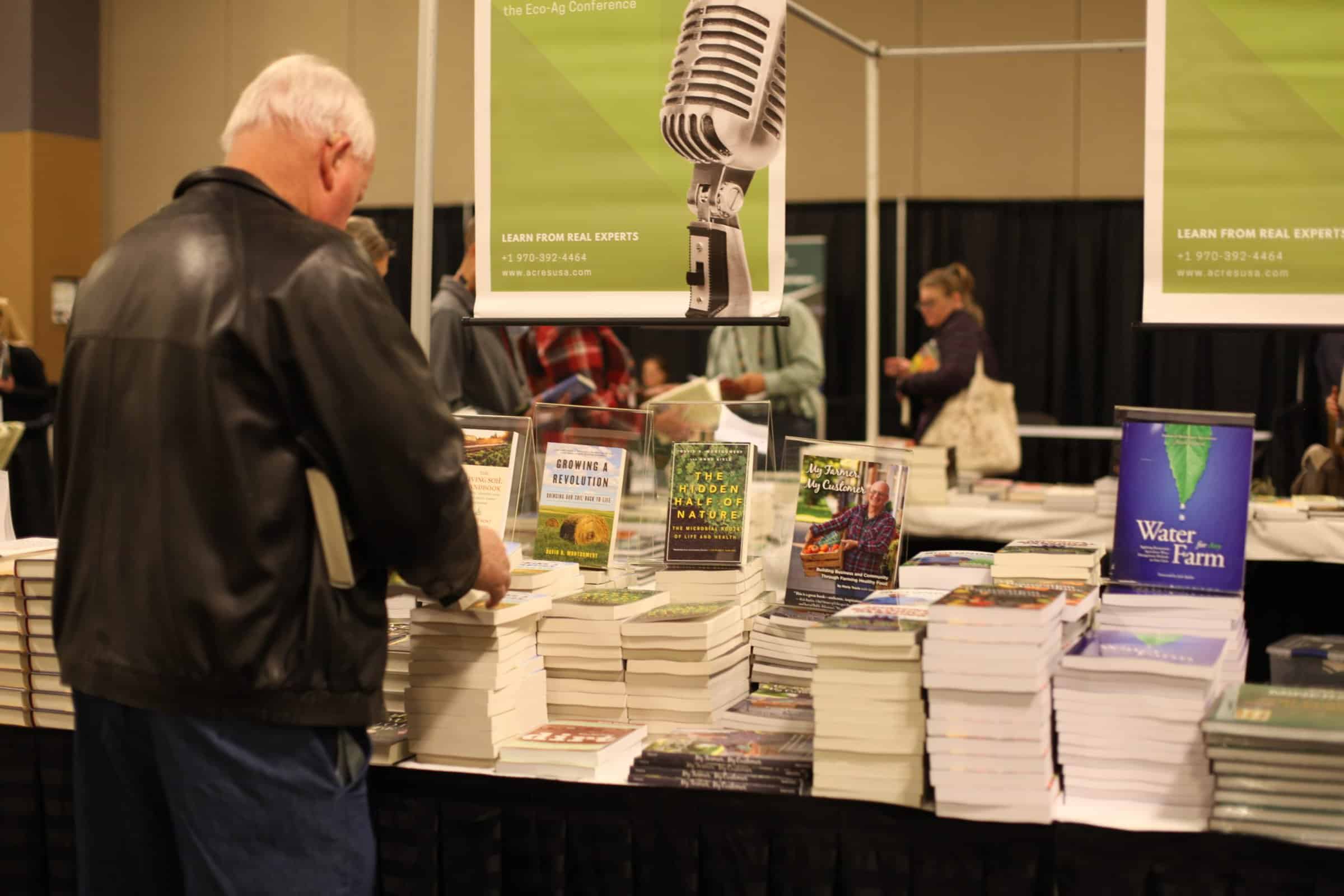 People browsing books at the Acres USA Eco-Ag Conference on-site bookstore